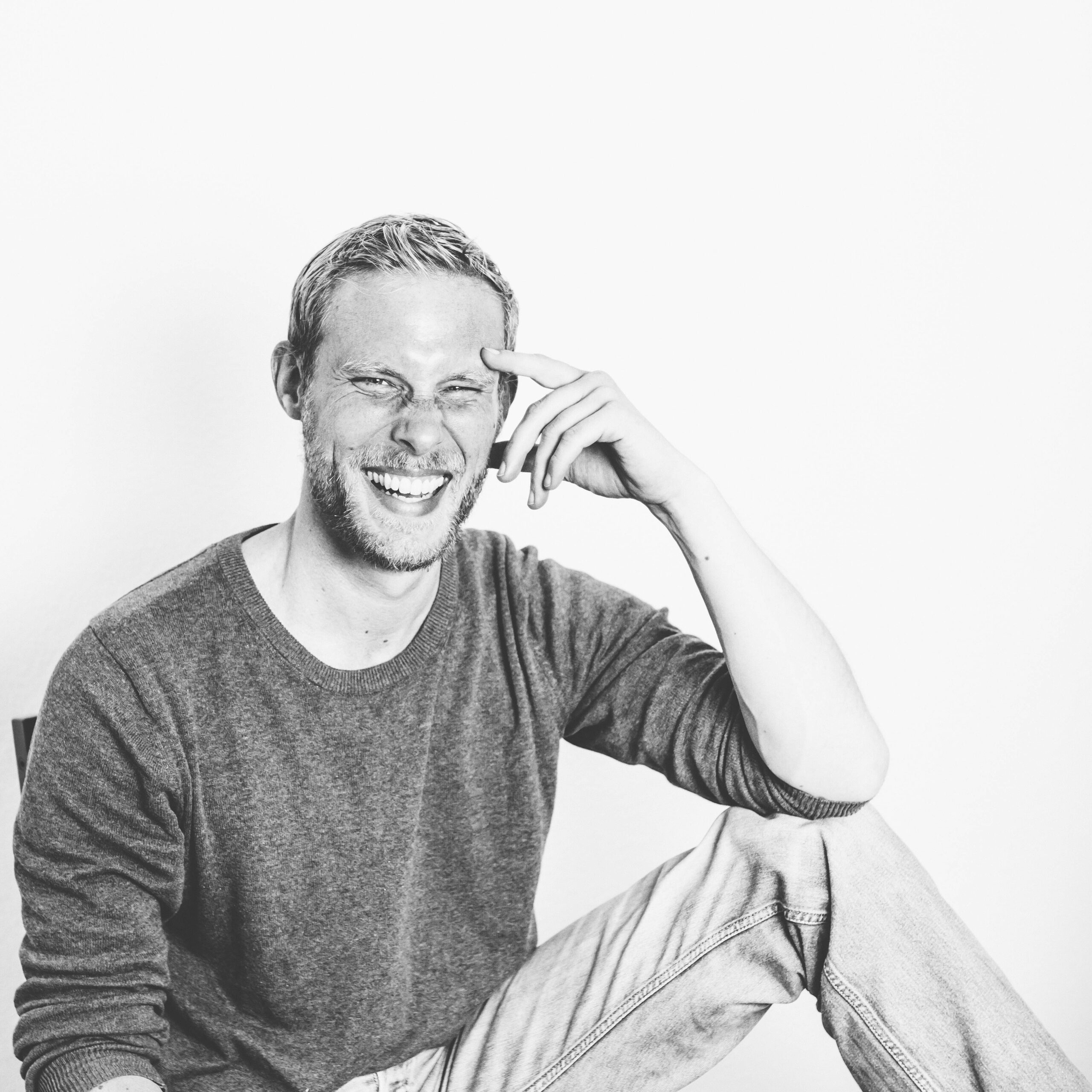 Dario Schwella sitzt auf einem Stuhl, das Foto ist schwarz weiß